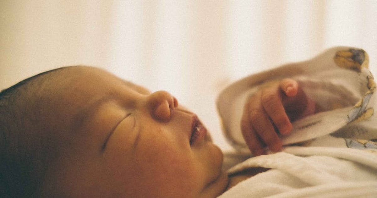 Close-up of a serene newborn baby sleeping wrapped in a cozy blanket.