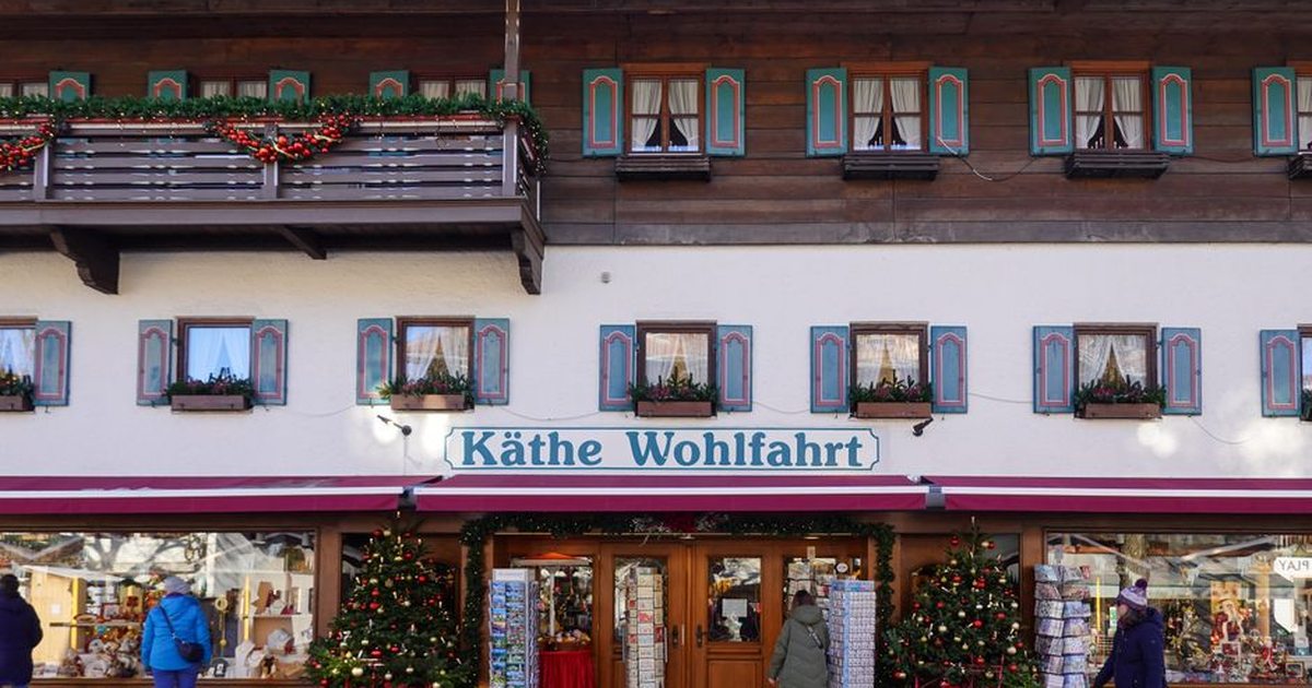 A charming alpine village store decorated for Christmas with festive ornaments and trees.