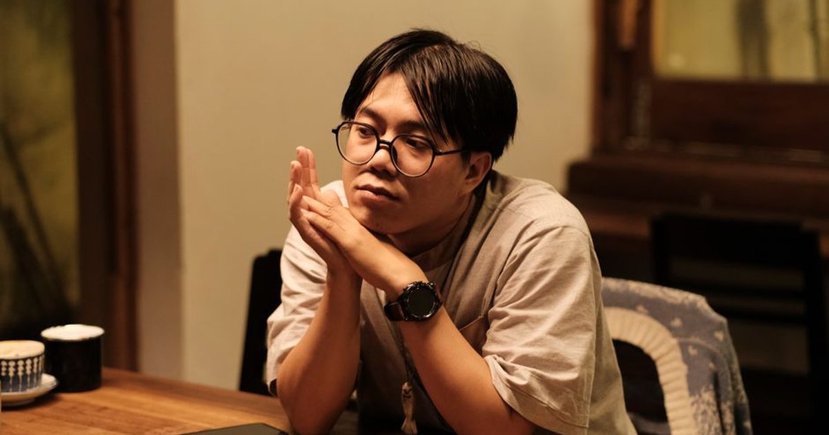 Contemplative young adult in a cozy Hue café, embodying personal style and introspective emotion.