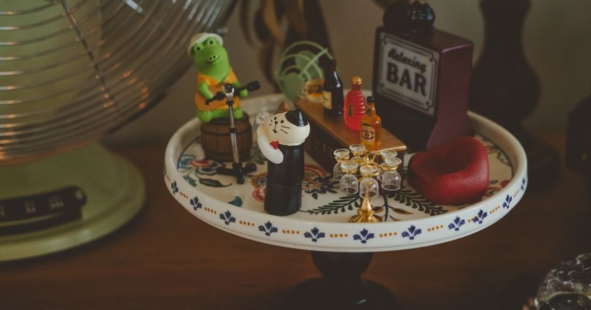 Charming miniature bar setup with playful figurines and tiny accessories on a decorative plate.