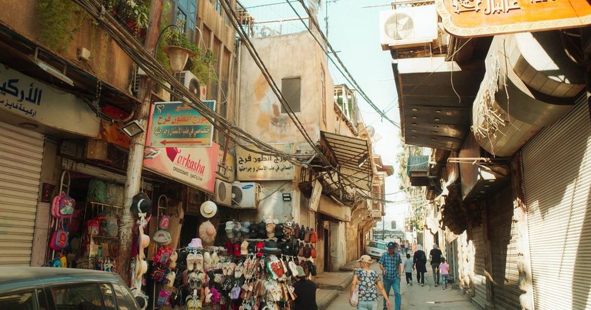 Vibrant street market scene with shops and people in a Middle Eastern town.
