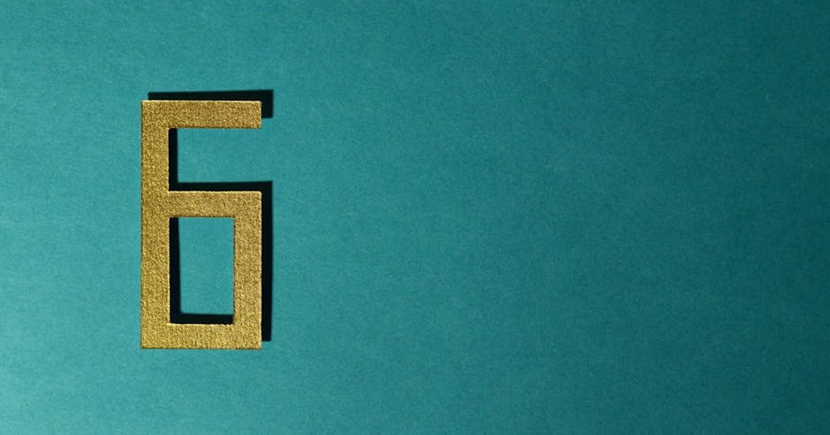 A golden number six on a teal background, perfect for decorative purposes.