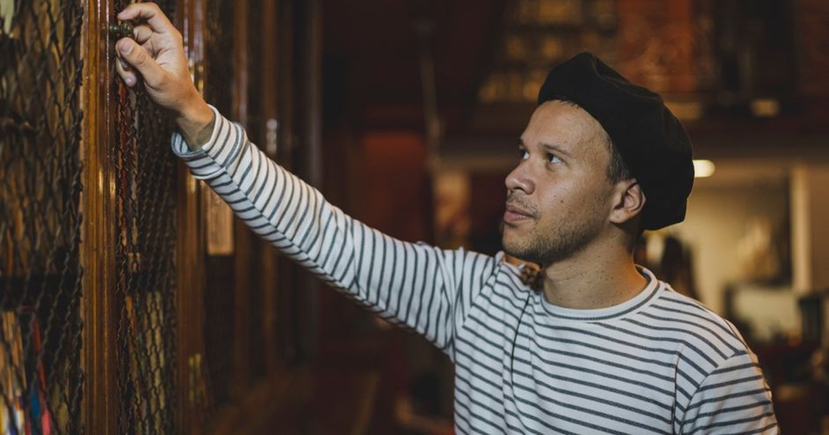 A man in a striped shirt examines a book in a historical library in Buenos Aires, Argentina.