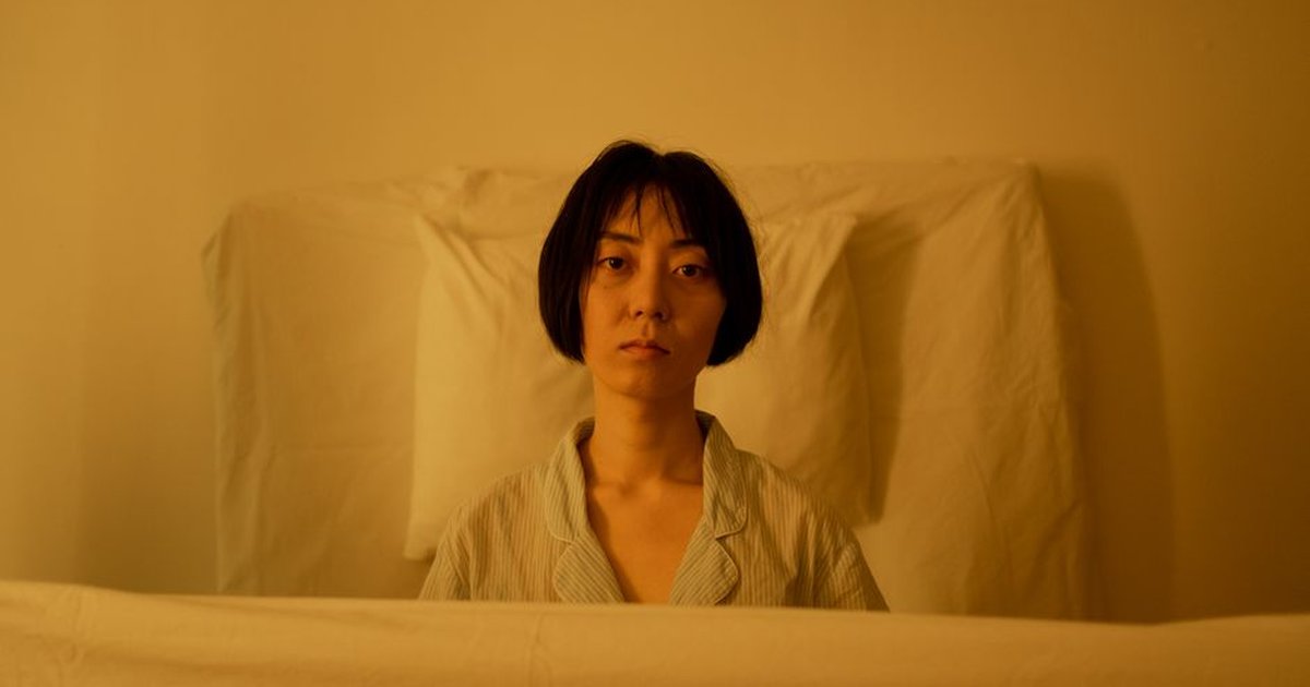 Portrait of a woman looking pensive and tired in soft lighting.