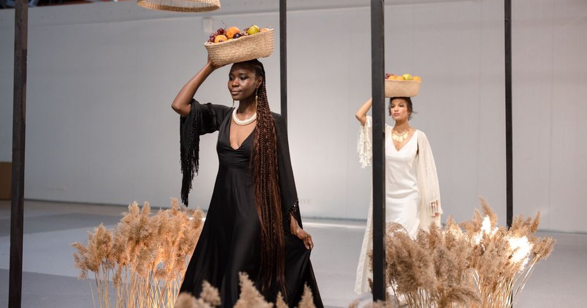 Elegant models in fashionable attire display fruit baskets on their heads, creating a sophisticated and artistic visual.