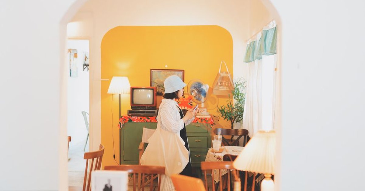 A woman in a retro-themed living room in Vũng Tàu, Vietnam, exudes a vintage vibe.
