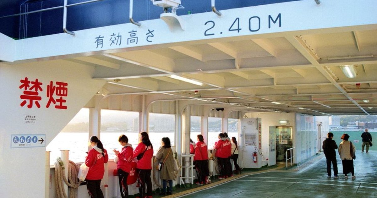 Travelers enjoy scenic views aboard a ferry in Hiroshima, Japan during sunset.