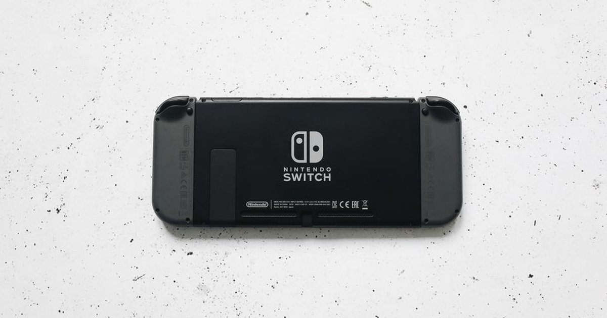 A close-up of a Nintendo Switch console placed on a textured marble surface, highlighting the device's sleek design.