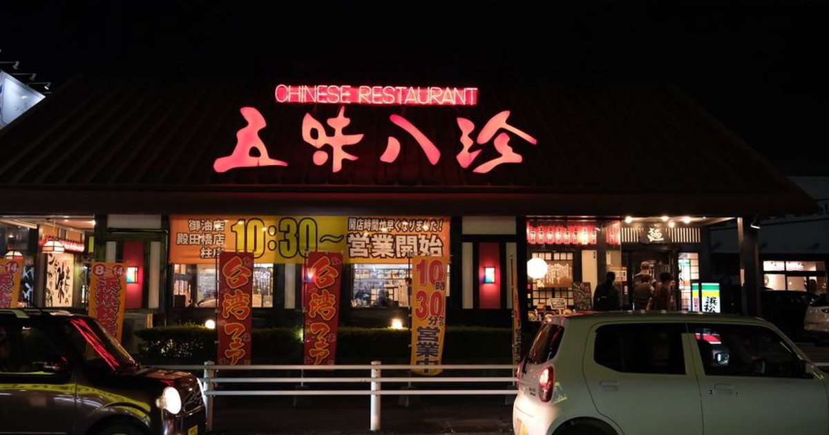 Illuminated Chinese restaurant in Toyohashi, Japan with cars at night.