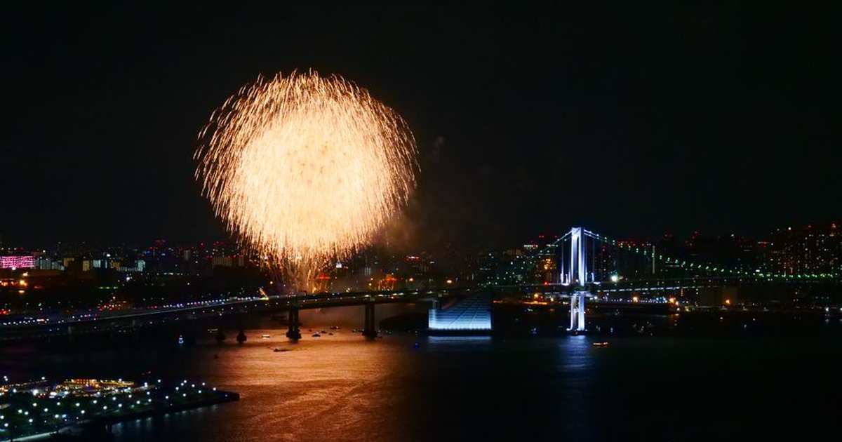 Spectacular fireworks over Rainbow Bridge in Tokyo Bay, Japan at night.