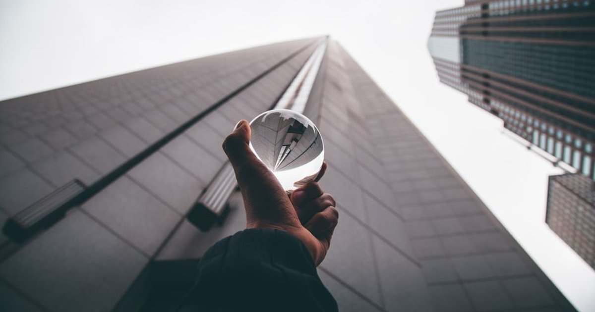 Perspective view of modern skyscrapers reflected in a crystal ball, showcasing urban architectural design.
