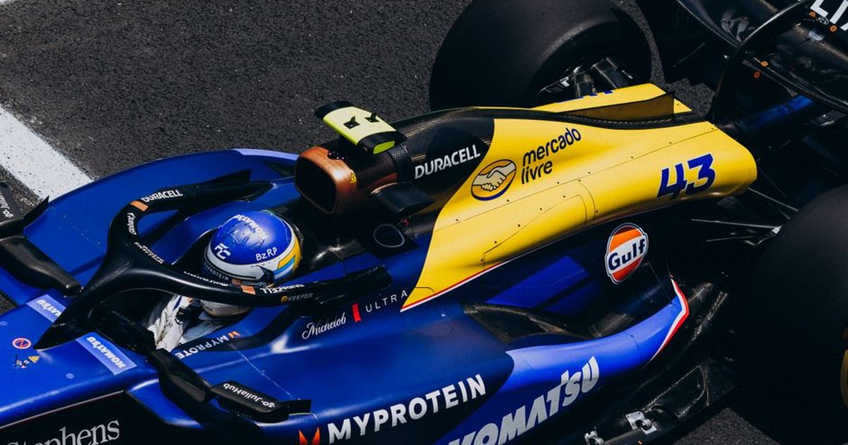 An overhead view of a colorful race car speeding on track, showcasing dynamic design and sponsorship logos.