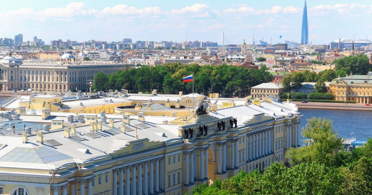 Aerial view of St. Petersburg featuring the Senate and Synod Building and Russian flag.