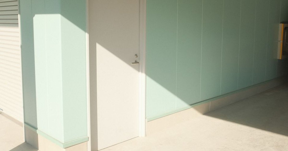 A minimalist indoor scene featuring a door with geometric shadows and pastel walls.