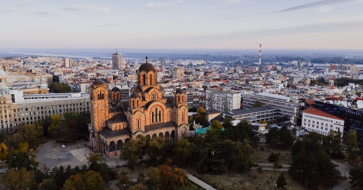 Captivating aerial view of Belgrade cityscape with St. Mark's Church at sunset.