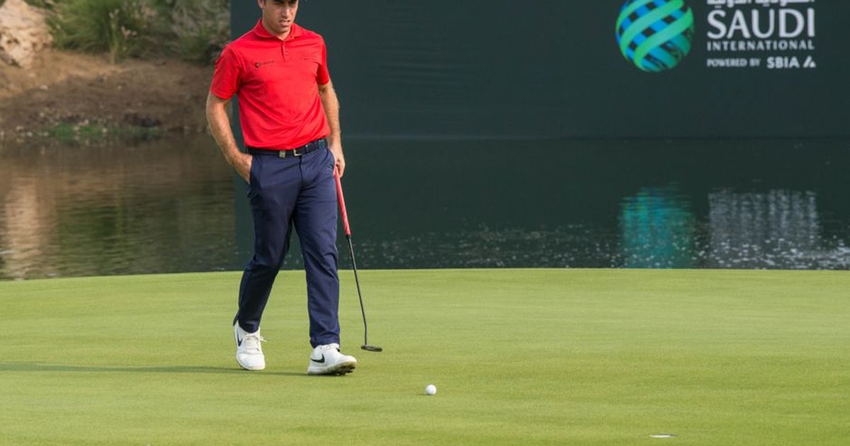 A male golfer in red shirt on a golf course at Saudi International event.