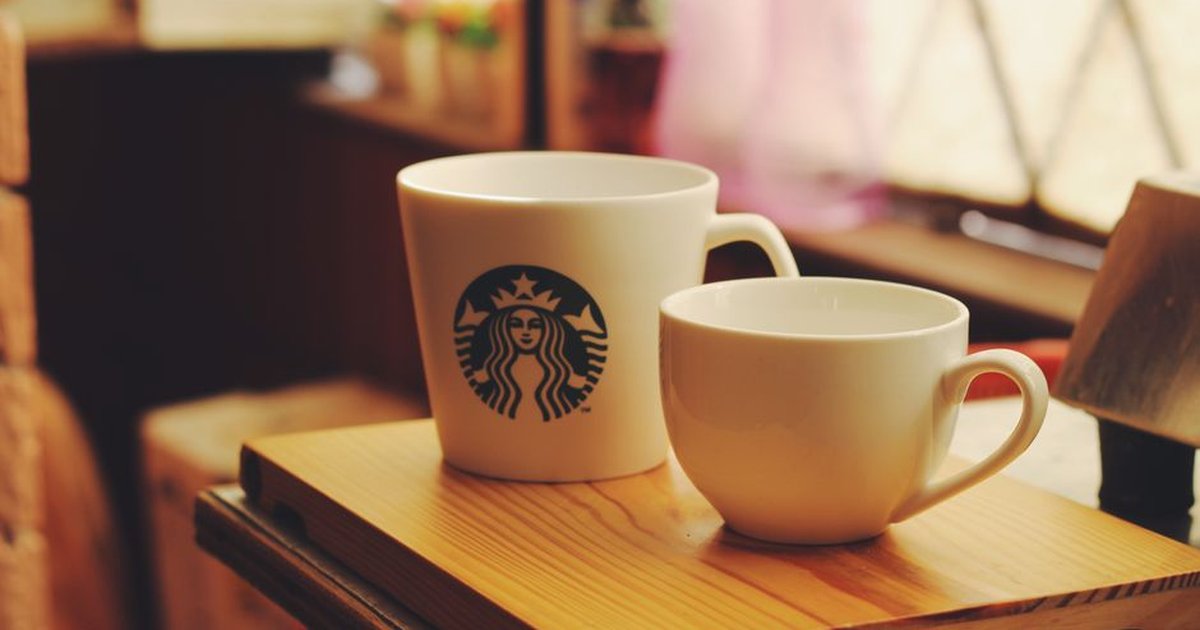A cozy scene featuring two ceramic coffee cups on a wooden tray, perfect for a warm morning.