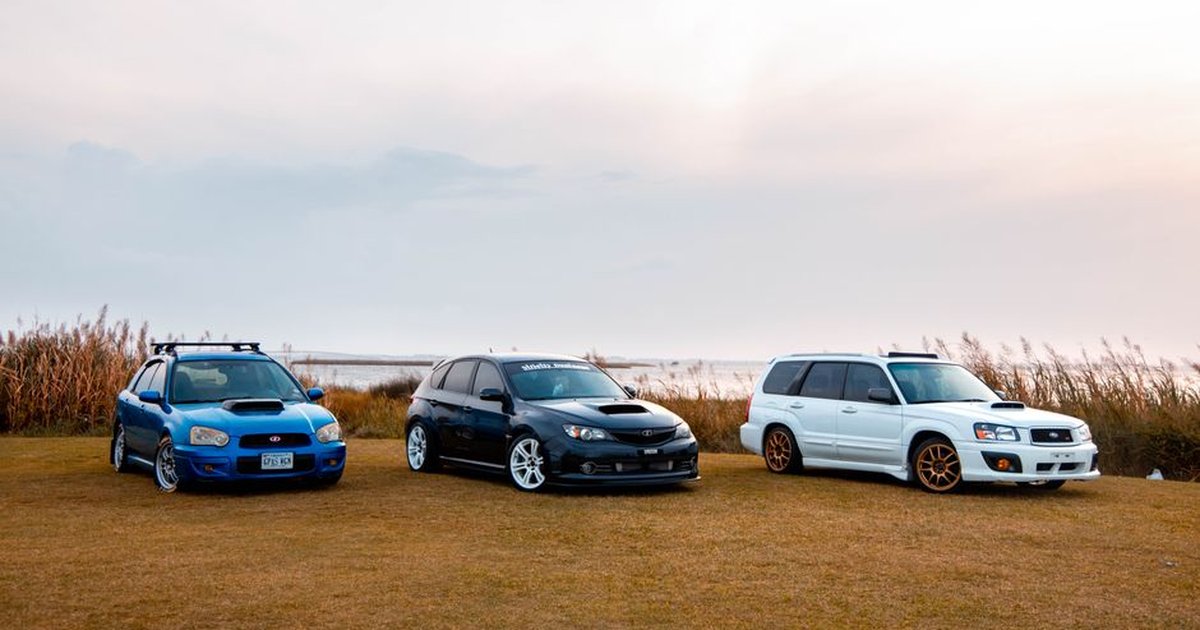 Three vehicles parked outdoors on grass during a clear daytime. Perfect for automotive enthusiasts.