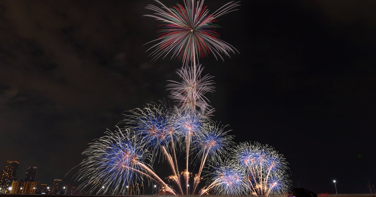 A breathtaking fireworks show illuminates the night sky over a city, showcasing vibrant colors against a dark backdrop.
