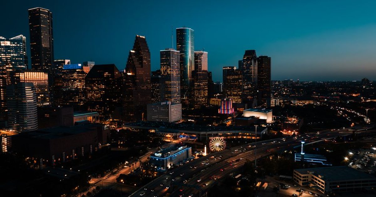 Stunning aerial view of downtown Houston's illuminated skyscrapers at dusk.