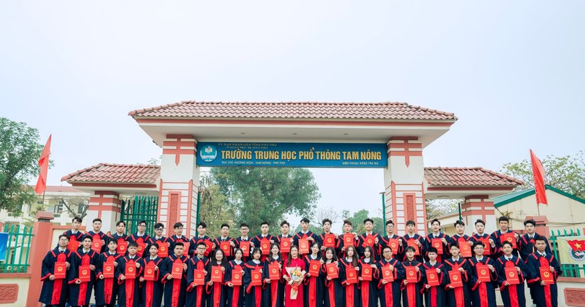 Graduating students pose with diplomas in front of Tam Nong High School in Vietnam.