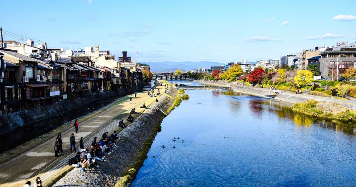 Beautiful scenery of Kamo River with cityscape and autumn foliage in Kyoto, Japan.