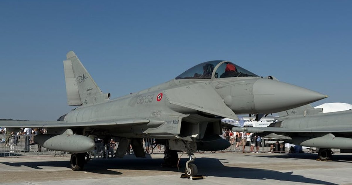 Eurofighter Typhoon at a daytime air show with gathering crowd.