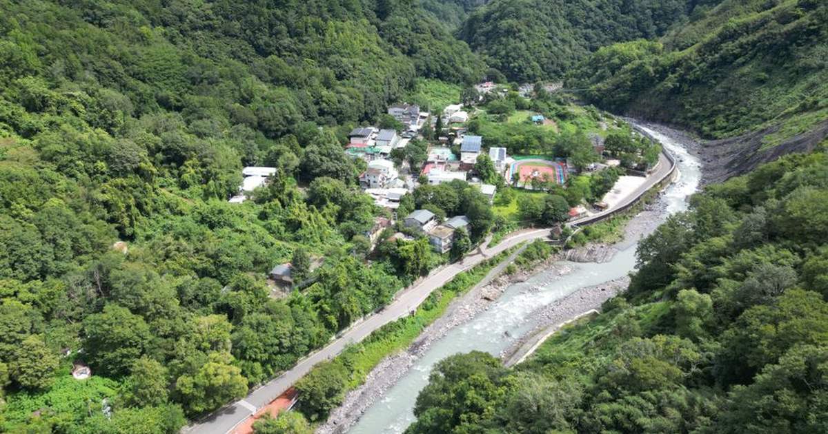Stunning aerial view of a lush river valley and village in Hsinchu County, Taiwan.