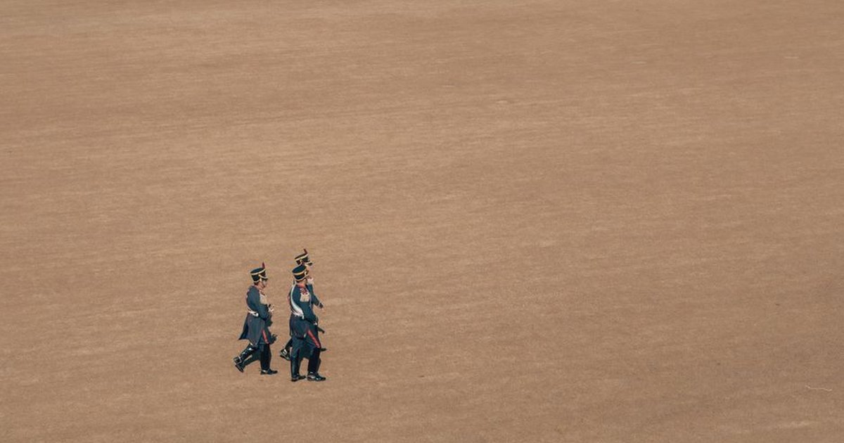Aerial view of Argentinian soldiers in uniform marching across a vast parade ground.