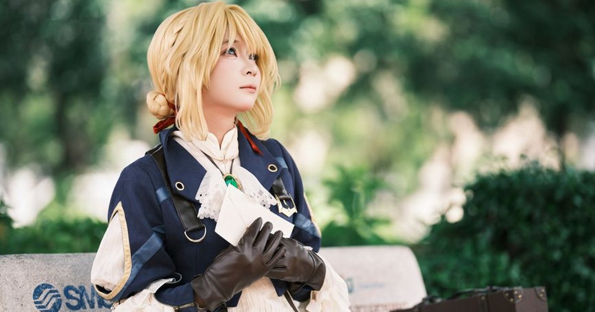 Cosplayer dressed in historical attire sits on park bench holding an envelope with greenery around.