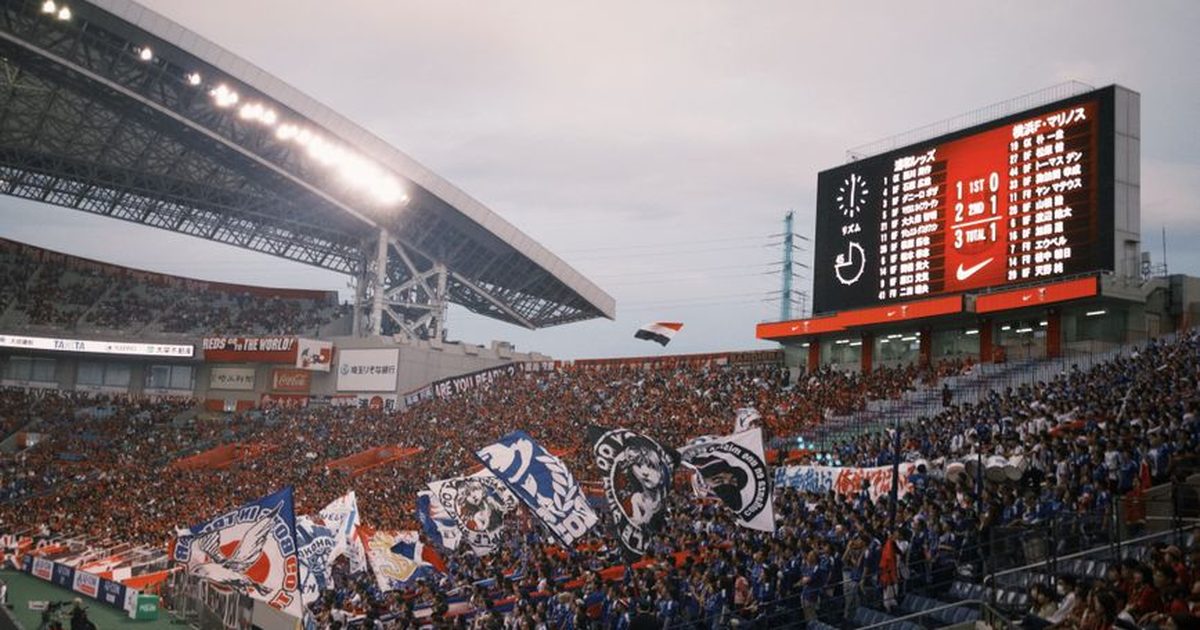 Energetic soccer match scene with cheering crowd and colorful flags in a large stadium.