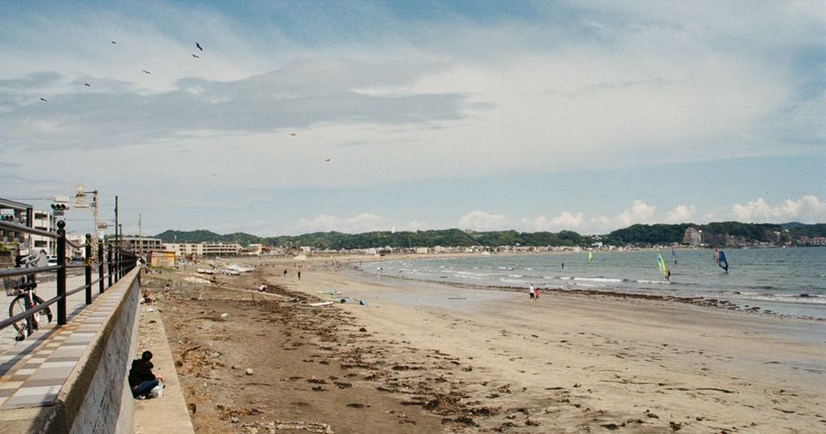 Tranquil beach scene with windsurfers in Kamakura, Japan. Perfect summer escape.