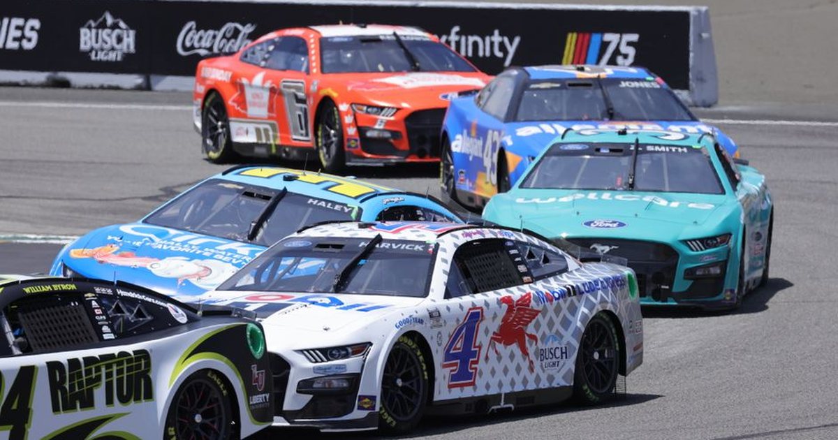 High-speed NASCAR cars race on a sunny day at a famous track, showcasing thrilling motorsport action.