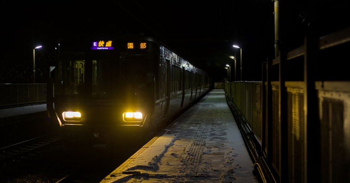 A train at Hozukyō Station in snowy Kameoka, Kyoto, Japan, during winter night.