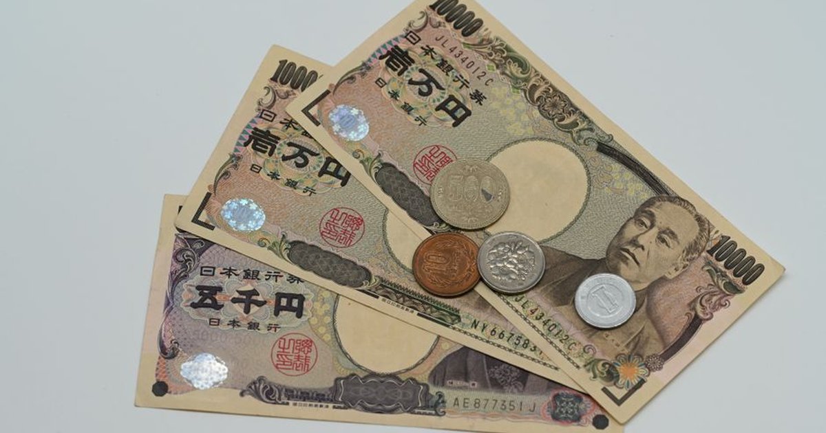 Close-up of Japanese Yen banknotes and coins arranged on a flat surface.