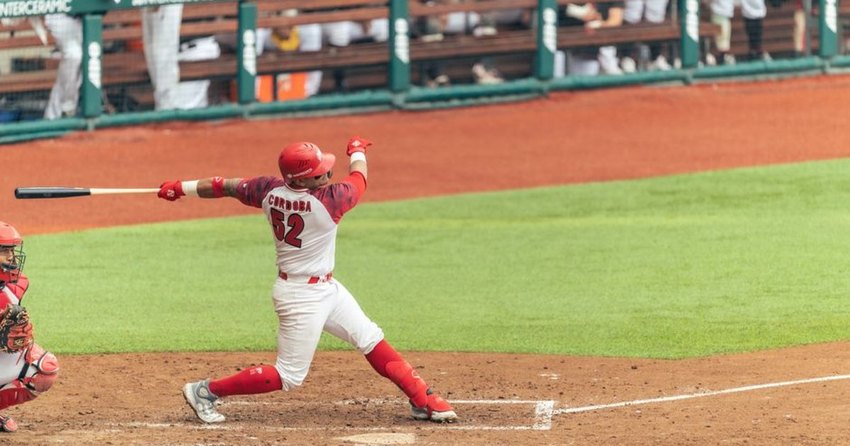 A baseball player powerfully swings the bat during a game, capturing the essence of competitive sports.