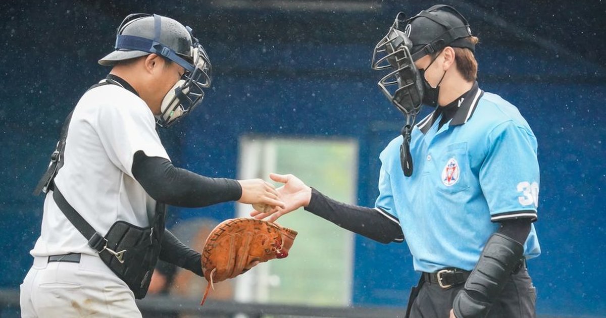 Baseball player shaking hands with an umpire on a rainy day.