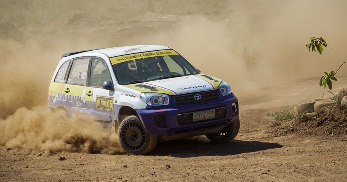 A dynamic off-road rally car kicks up dust in Calabarzon, Philippines, showcasing thrilling speed and precision.
