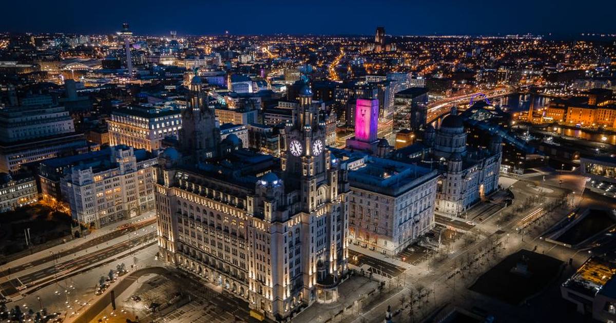 Stunning aerial image of Liverpool's skyline at night showcasing iconic buildings and city lights.