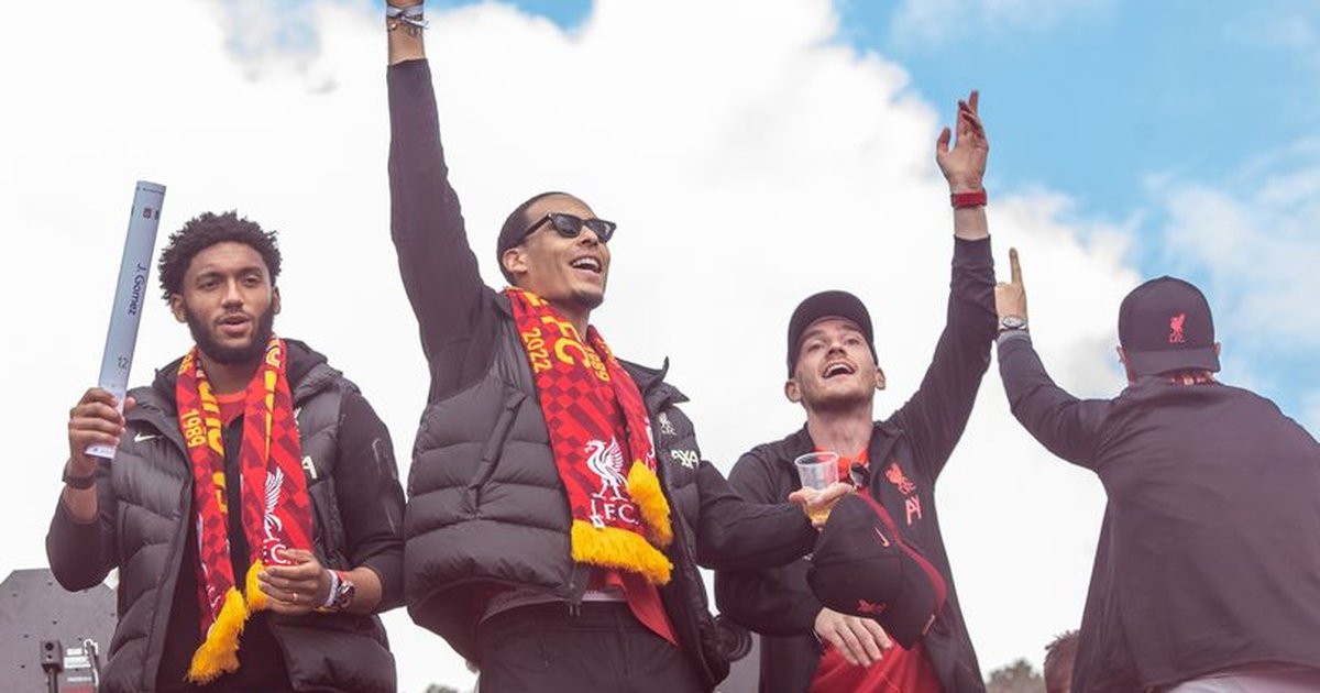 Fans celebrate with Liverpool FC players during a victory parade in Liverpool, England.