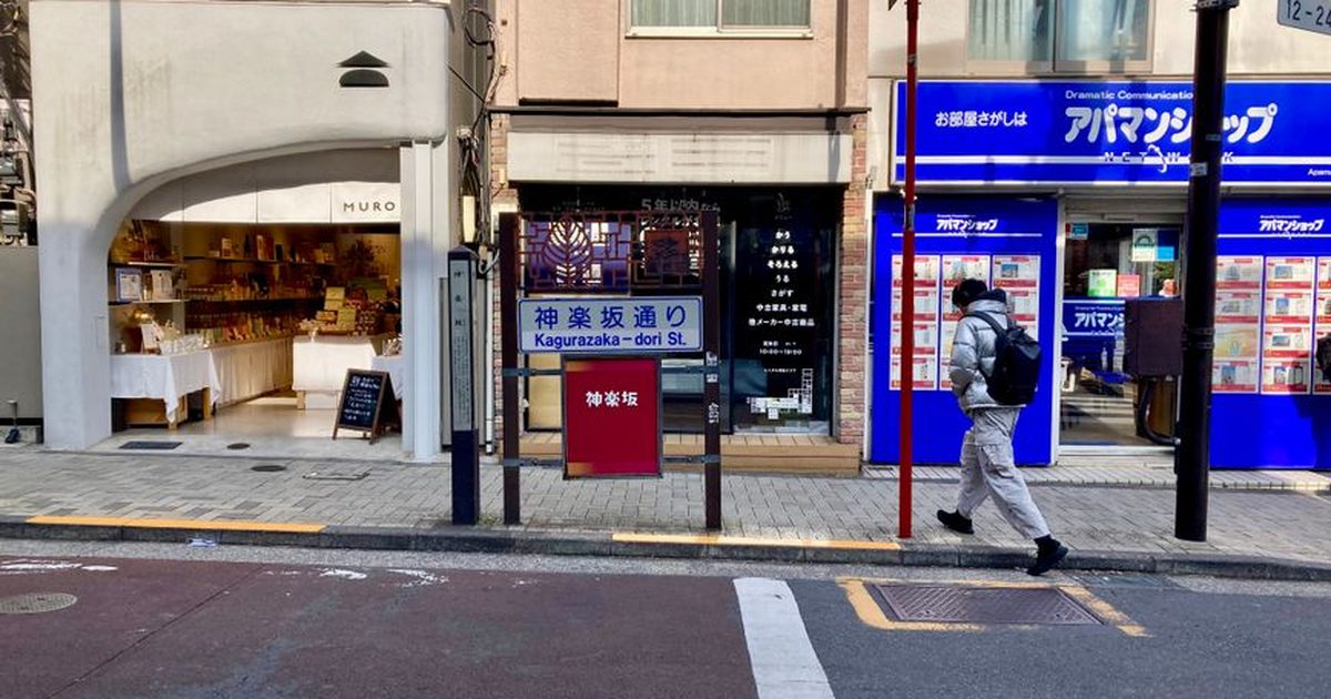 A man walking past shops on Kagurazaka-dori Street in Tokyo, Japan.