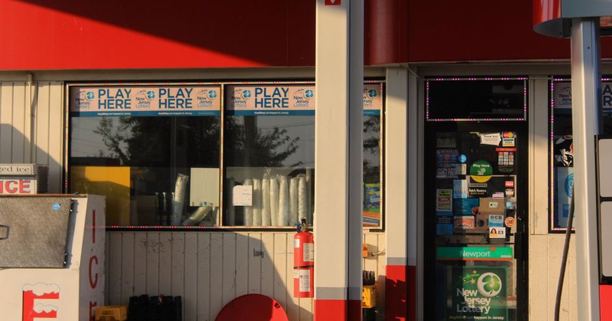 Convenience store entrance at a gas station featuring lottery signs in Bridgeton, New Jersey.