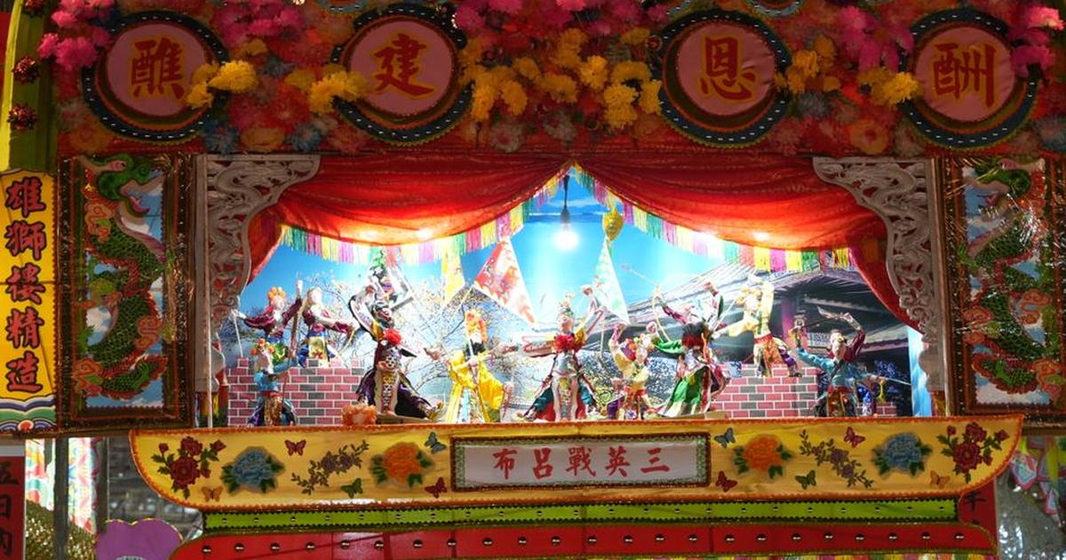 Vibrant display from the Piu Sik parade in Hong Kong's New Territories featuring colorful decorations and figures.