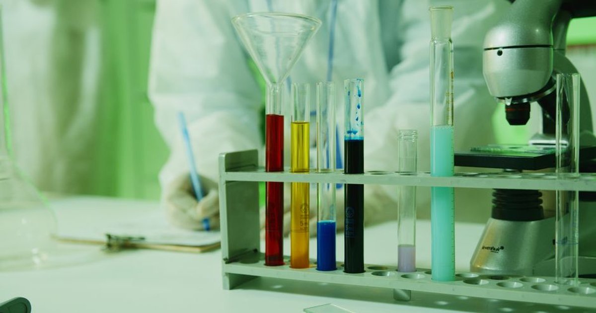 Close-up photo of lab research setup with test tubes and a microscope.