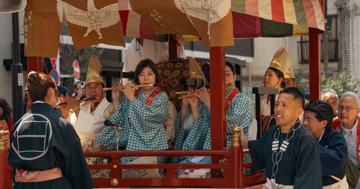 Musicians play flutes during a colorful traditional festival parade in Tokyo, Japan.