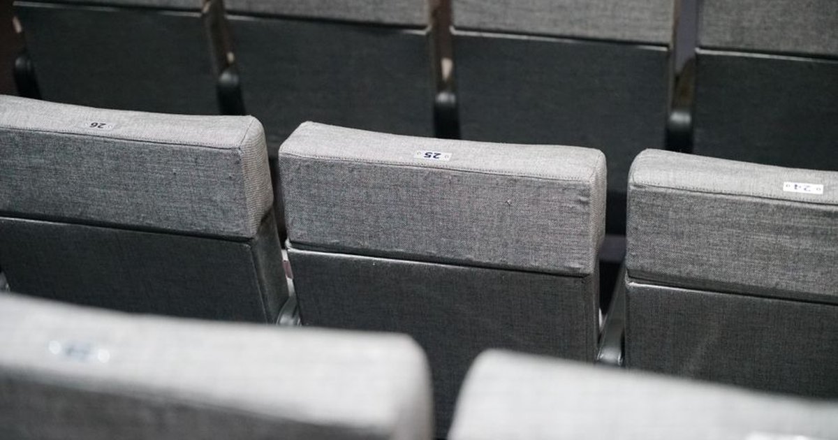 Close-up of empty gray theater seats arranged in neat rows. Perfect for cinema and event scenes.