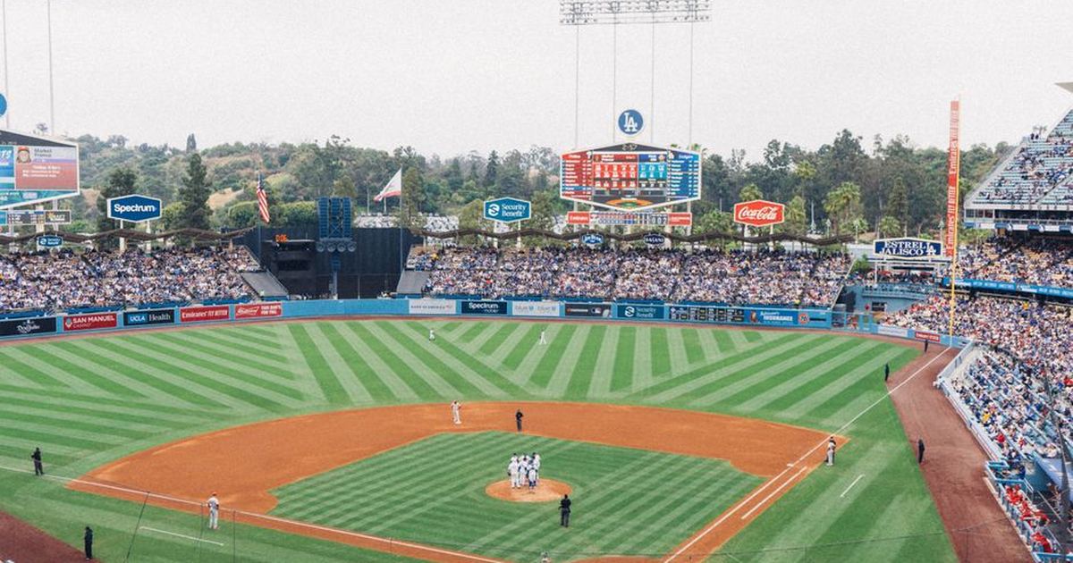 Vibrant baseball game at Dodger Stadium with packed stands and players on the field.