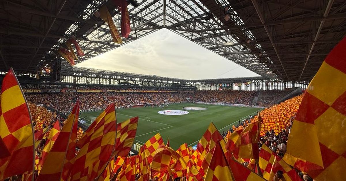 Energetic fans with flags create a lively atmosphere at İzmir football stadium.