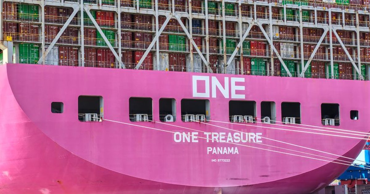 A large pink container ship named ONE Treasure docked in Panama for cargo loading.