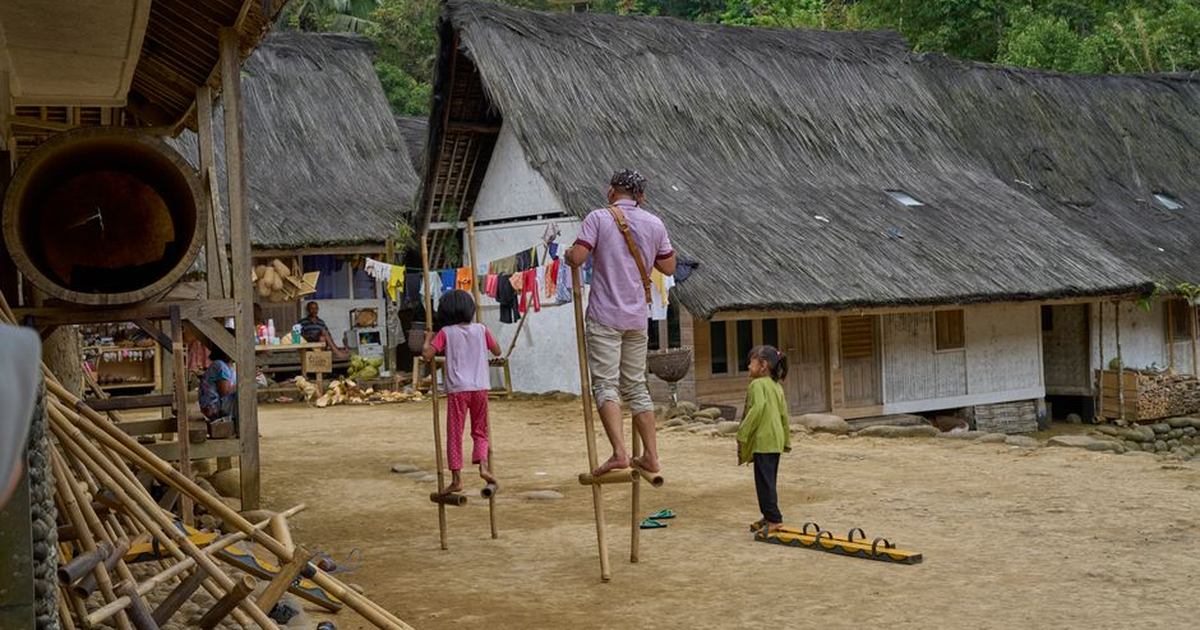 A vibrant depiction of a rural village with children practicing stilt walking.